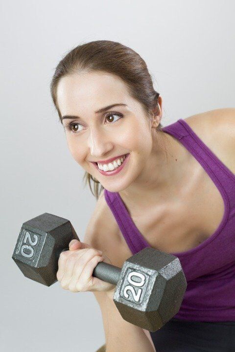 a girl with dumbbells doing exercises to lose weight